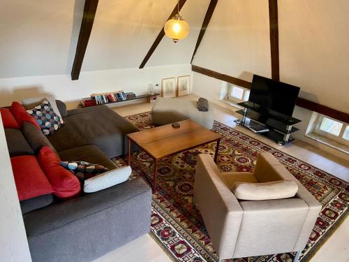 a living room with a couch and a table at Ferienhaus Tante Elses - Ruhe & Erholung zwischen den Meeren - gemütliche & stilvolle Ausstattung in Süderhöft