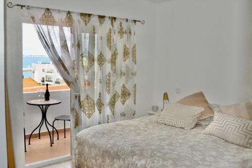 um quarto com uma cama, uma mesa e uma varanda em In the Old Town close to the Beach em Lagos