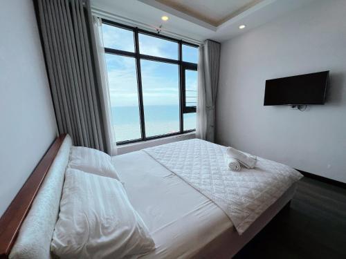 um quarto com uma cama grande e uma janela grande em Căn 3434-Tòa 1A Mường Thanh Viễn Triều em Nha Trang