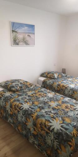 deux lits côte à côte dans une chambre dans l'établissement MAISON DANS LE CHARMANT VILLAGE DE LA VRAIE-CROIX, à La Vraie-Croix