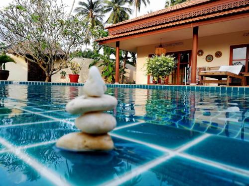 a stack of rocks sitting on top of a swimming pool at Laura's Guest House-adult only- in Lamai