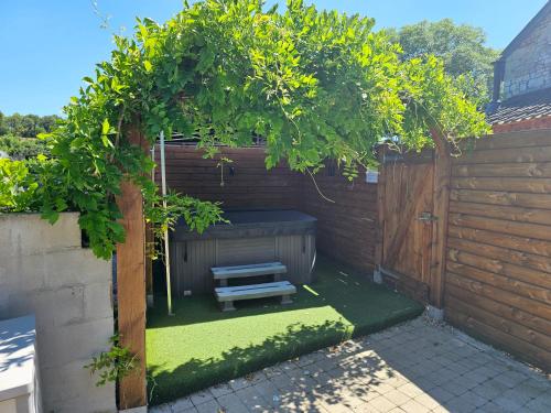 a garden with a bench under a wooden fence at Durbuy Nature in Durbuy