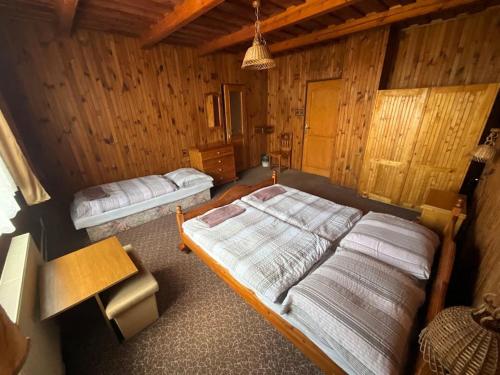 um quarto com 2 camas num chalé de madeira em Penzión Heľpa (do 25 hostí) em Heľpa