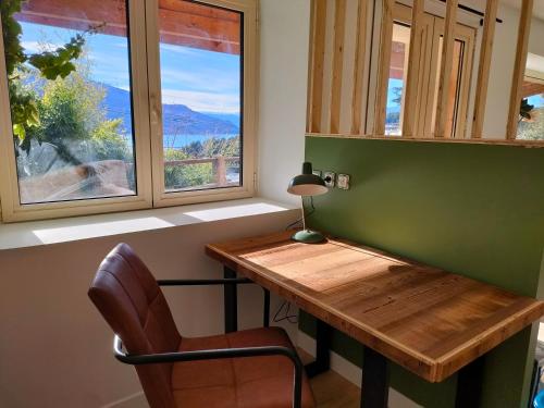a desk in a room with a window and a chair at Le Panoramique du Plongeoir - T4 spacieux de 90m2 avec grande terrasse vue sur le lac de Serre Ponçon in Savines