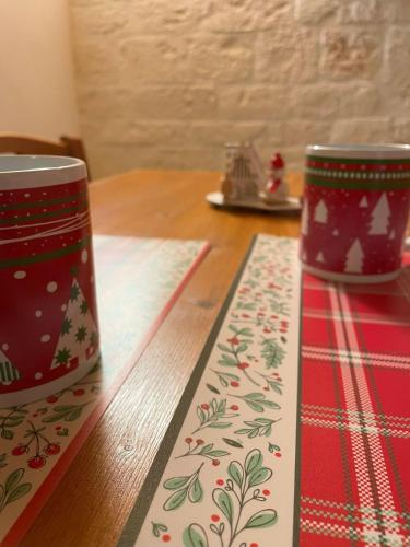 two christmas mugs sitting on top of a wooden table at La Casetta di Lucia in Alberobello