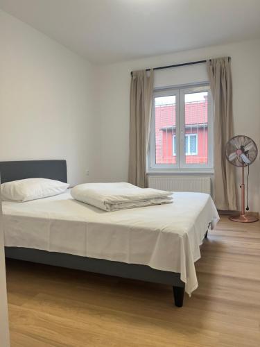 1 cama en un dormitorio con ventana y ventilador en Apartment Zhang, en Graz