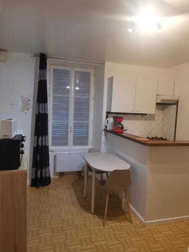- une petite cuisine avec une petite table et un comptoir dans l'établissement T1 bis centre ville d'Aurillac, à Aurillac