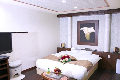Un dormitorio con una cama grande con un arreglo floral. en パルアネックス鹿島店, en Ureshino