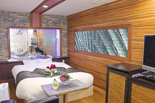 Habitación de hotel con 2 camas y TV en パルアネックス鹿島店 en Ureshino