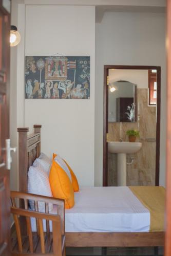 a bedroom with a bed and a mirror and a sink at Villa Windfall Unawatuna in Unawatuna