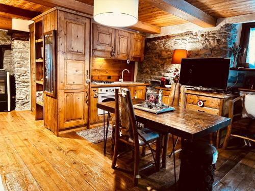 a kitchen with wooden cabinets and a wooden table at Maison Bovet in La Salle