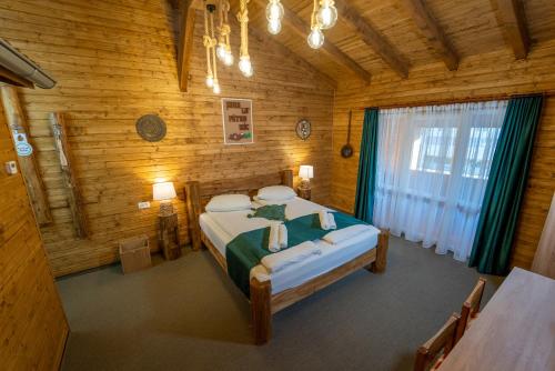 a bedroom with a bed in a wooden room at ȘURA LU' PĂTRU in Vulcan