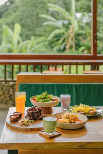 a table with plates of food and drinks on it at Glamping tent in Pelaga Eco Park in Patjung