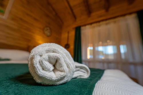 uma pilha de toalhas sentadas em cima de uma cama em ȘURA LU' PĂTRU em Vulcan