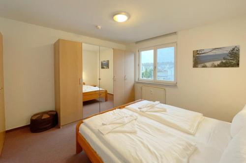 a bedroom with a white bed and a window at Inselhaus Karlstrasse 6a Ferienwohnung 4 in Stubbenfelde