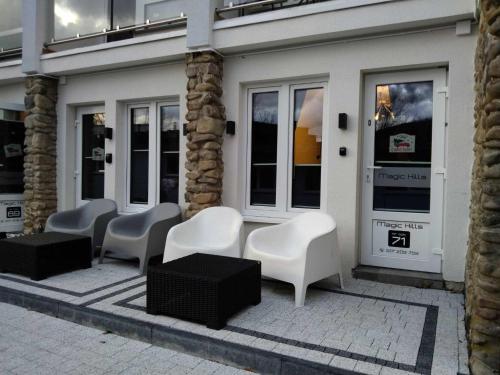 a row of white chairs sitting outside of a store at MAGIC HILLS in Ustroń