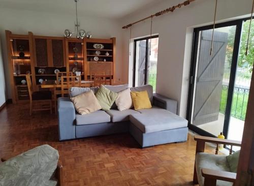 Santi Guesthouse : غرفة معيشة مع أريكة زرقاء ومطبخ