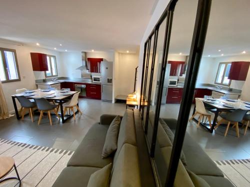 un salon avec un canapé et une cuisine avec des tables dans l'établissement Notre cocon des remparts, à Aigues-Mortes