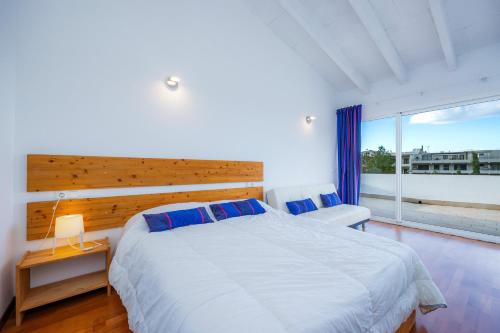 a bedroom with a large bed and a large window at Casa Miquel-betlem in Colonia de Sant Pere