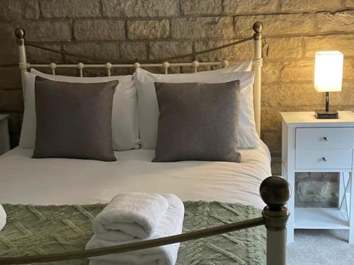 a bedroom with a white bed with pillows and a lamp at Peak District Stay Stylish for 2 Pass the Keys in New Mills