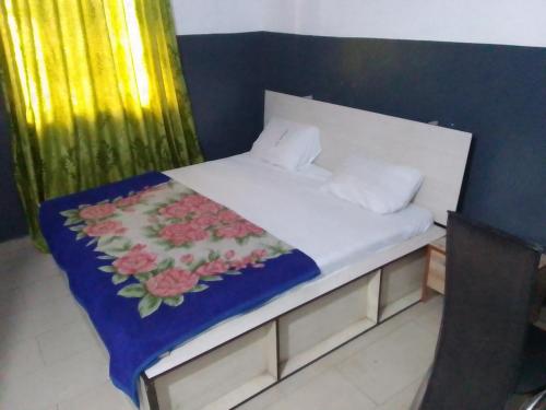 a bedroom with a bed with a flower blanket on it at MARVELLOUS hotel in Lagos