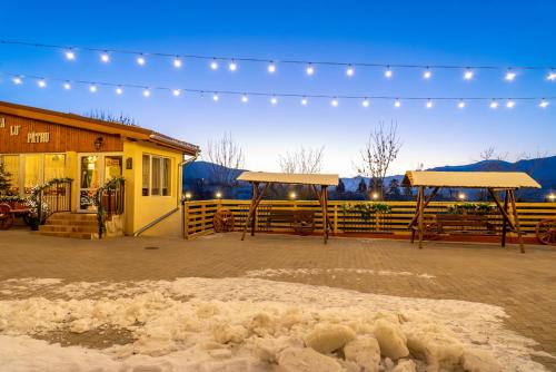 a building with lights and snow in front of it at ȘURA LU' PĂTRU in Vulcan