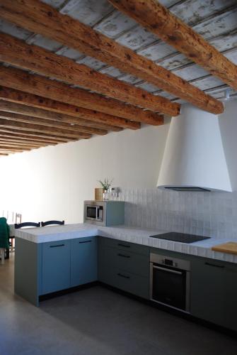 a kitchen with blue cabinets and a stove top oven at Casa de Agustín in Valverde del Majano