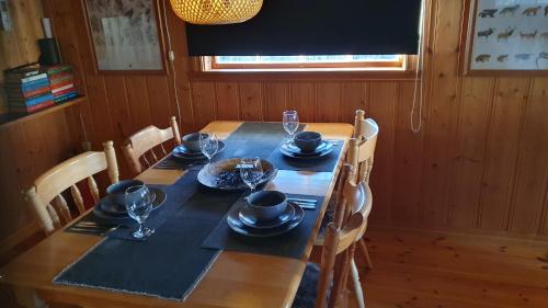 a dining room table with a black table cloth and glasses at Vikinggård Cottages in Höljes