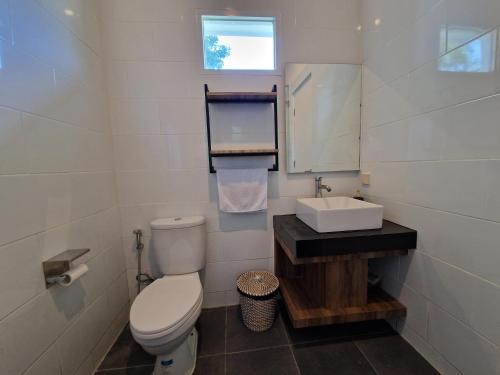 a small bathroom with a toilet and a sink at Villa Norwegia - pool with panorama rice field view in Yogyakarta