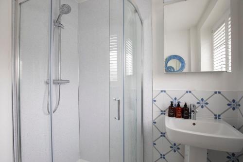 La salle de bains est pourvue d'une douche et d'un lavabo. dans l'établissement Central 1 Bedroom Apartment with Parking, 