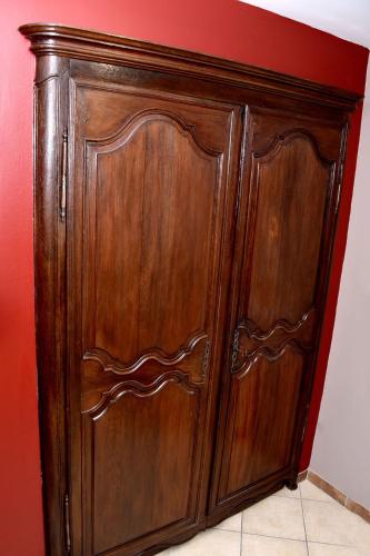 a wooden cabinet in a room with a red wall at Chez Mongauld in Verdun