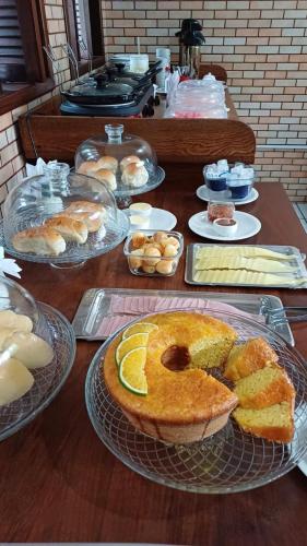 una mesa cubierta con pasteles y pastas en los platos en Pousada Ventos Do Mar, en Natal