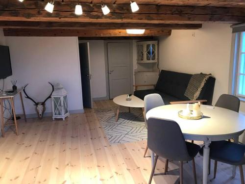 een woonkamer met een bank en een tafel bij Nyrenoverad stuga nära naturen in Linköping