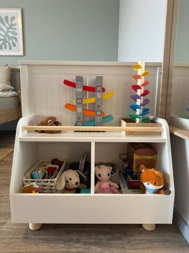 a white cabinet filled with stuffed animals and toys at Apartment Strandzeit in Kolpinsee