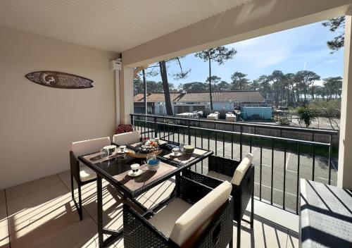 d'un balcon avec une table et des chaises et une vue sur l'eau. dans l'établissement Biscawaï studio spacieux et cosy, à Biscarrosse