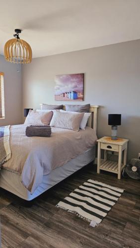 een slaapkamer met een groot bed en een tafel bij SS Luxury Apartments in Kaapstad