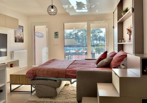 une chambre avec un lit et une grande fenêtre dans l'établissement Biscawaï studio spacieux et cosy, à Biscarrosse