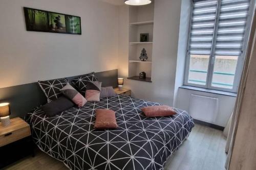 1 dormitorio con cama blanca y negra con almohadas en Superbe appartement avec parking en Saint-Junien