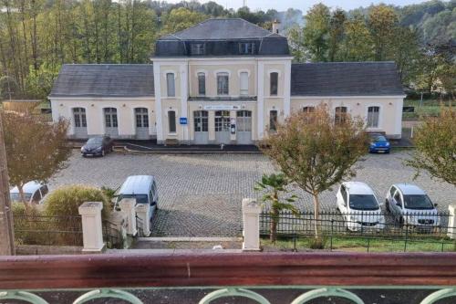 une grande maison blanche avec des voitures garées dans un parking dans l'établissement Superbe appartement avec parking, à Saint-Junien