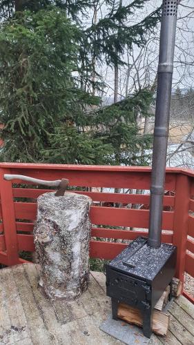 a black stove sitting in front of a red fence at Vikinggård Cottages in Höljes