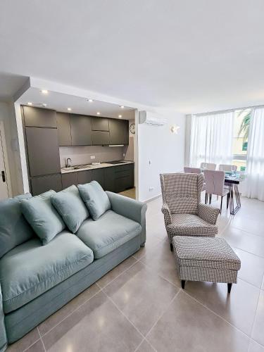 een woonkamer met een blauwe bank en 2 stoelen bij P&L HOUSE Las Olas in Playa del Inglés