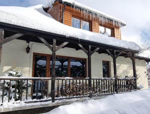 a house covered in snow with a fence at Mountain House in Ustrzyki Dolne