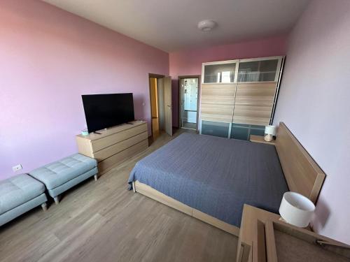 a bedroom with a bed and a flat screen tv at Вила Маунтайн Вю in Brestnik