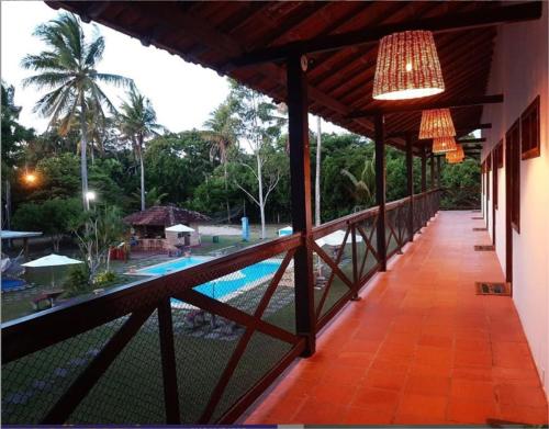 a balcony of a resort with a pool and a chandelier at Pousada Casarão de Itaúnas in Itaúnas