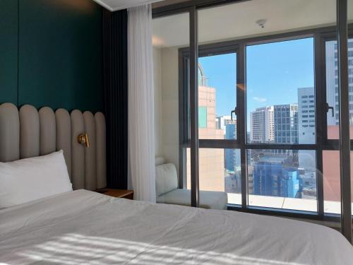 a bedroom with a bed and a large window at The solid residence - Elbon the stay by haeundae in Busan