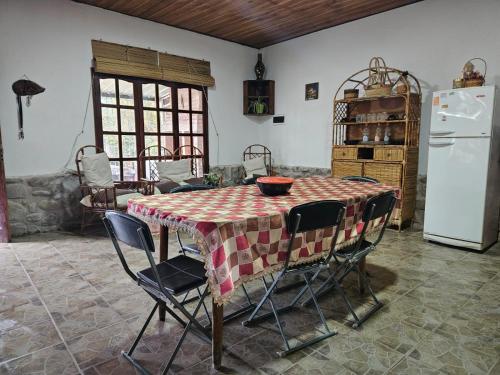 eine Küche mit einem Tisch mit Stühlen und einem Kühlschrank in der Unterkunft CASA EN VAQUEROS SALTA CAPITAL PARA 8 PERSONAS in Vaqueros