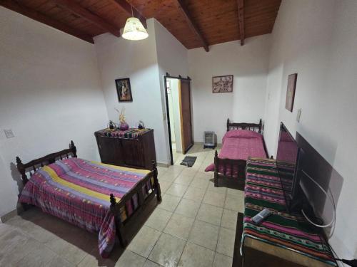 1 Schlafzimmer mit 2 Betten und einem Flachbild-TV in der Unterkunft CASA EN VAQUEROS SALTA CAPITAL PARA 8 PERSONAS in Vaqueros