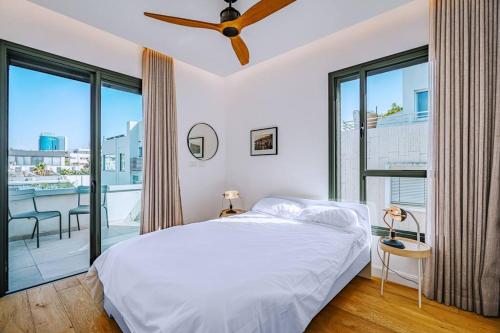 a bedroom with a bed and a large window at Shenkin Dream - 4 BR in Tel Aviv