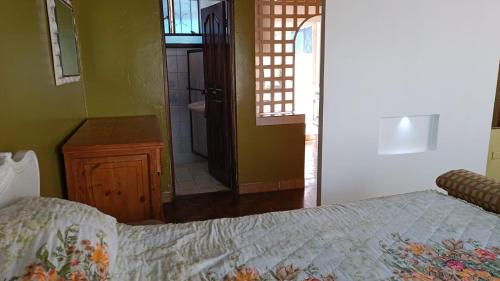 een slaapkamer met een bed en een deur naar een badkamer bij Casa de La Hiedra.Alojamiento para ejecutivos. in Sangolquí