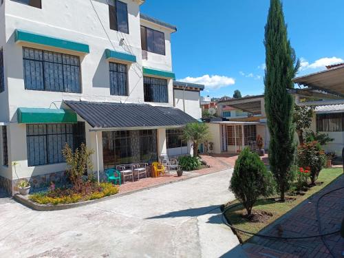 een groot wit gebouw met een patio ervoor bij Casa de La Hiedra.Alojamiento para ejecutivos. in Sangolquí